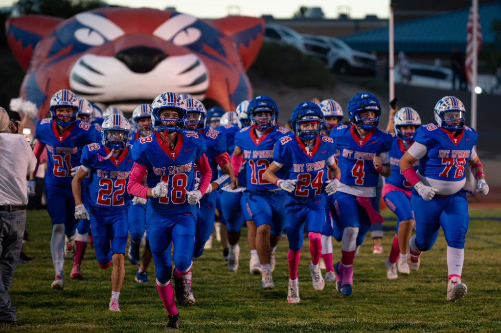 Hot Springs Tigers football players run onto the field at Tiger Stadium before their game against Hatch Valley.