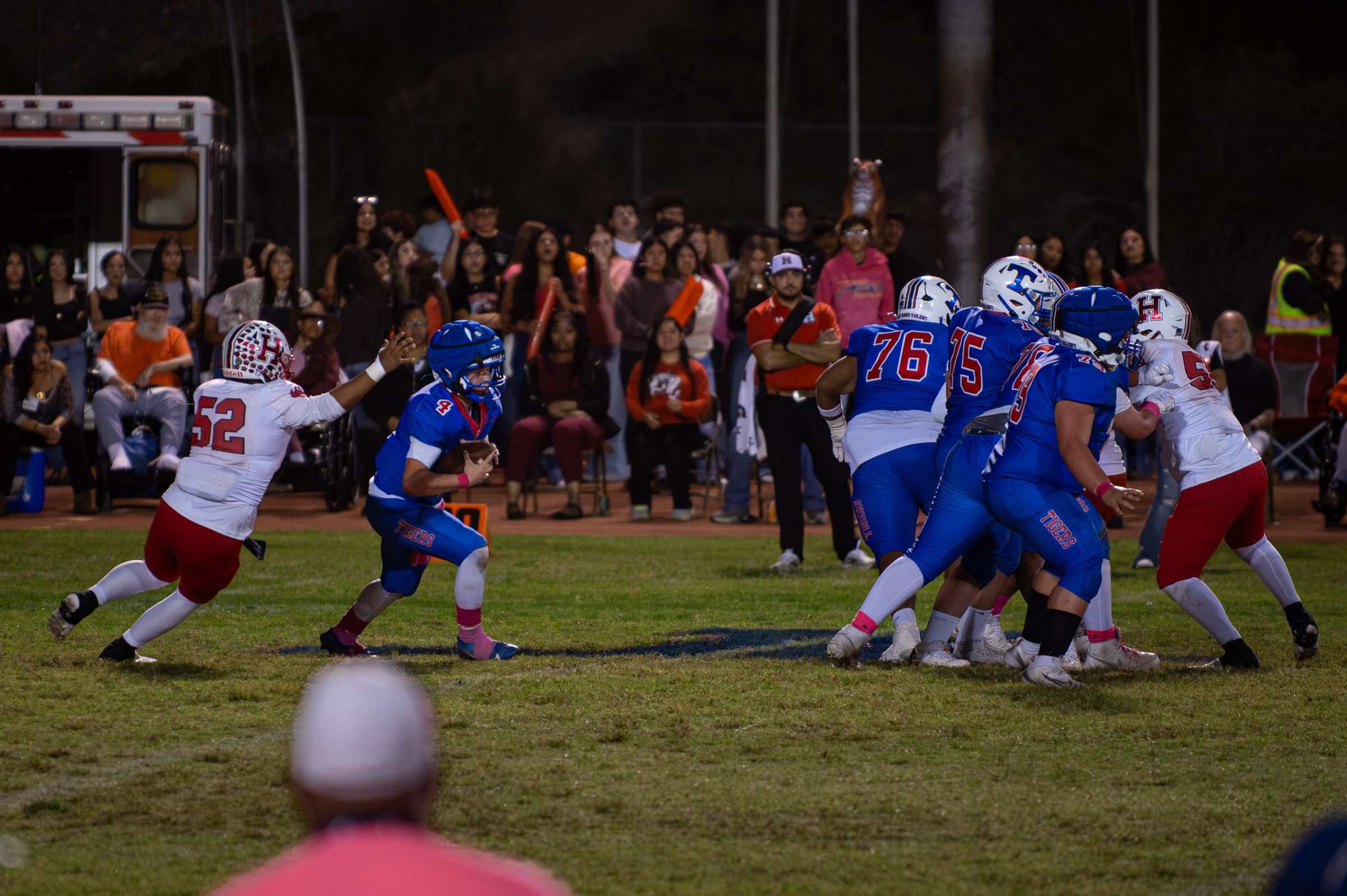 Hot Springs quarterback Zaiden Baker (#4) scrambles away from Hatch Valley defender #52 as his offensive line blocks.