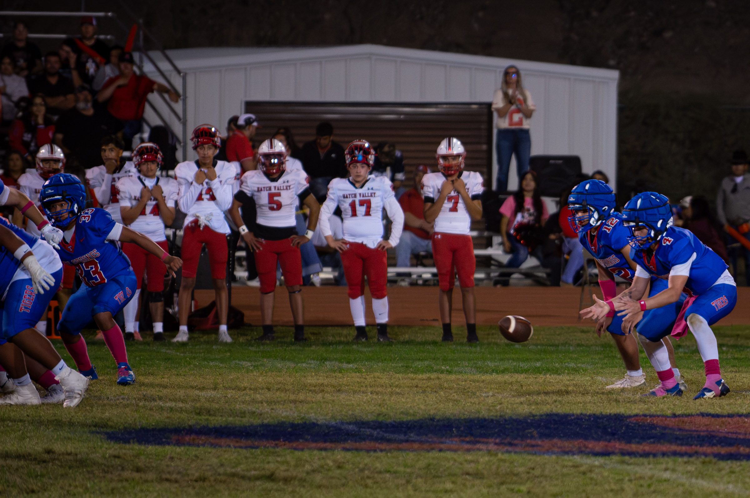 Hot Springs quarterback Zaiden Baker (#4) reaches down to field a low snap as the play develops against Hatch Valley.
