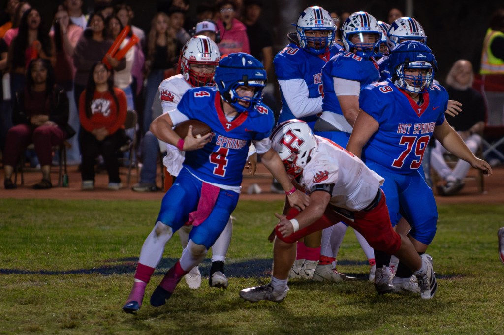 Hot Springs quarterback Zaiden Baker carries the ball as a Hatch Valley defender closes in.