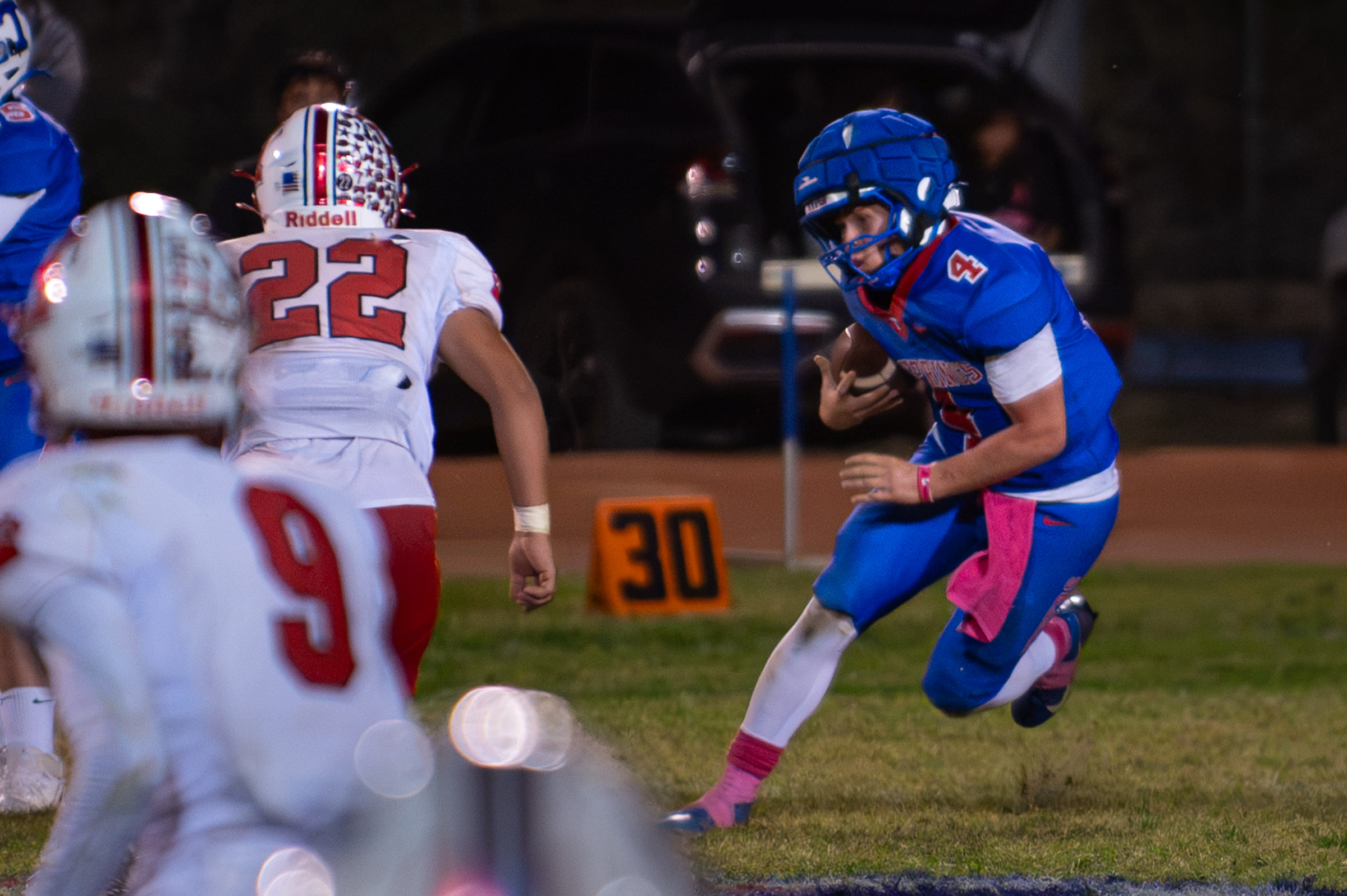 Hot Springs quarterback Zaiden Baker (#4) carries the ball toward Hatch Valley defenders.