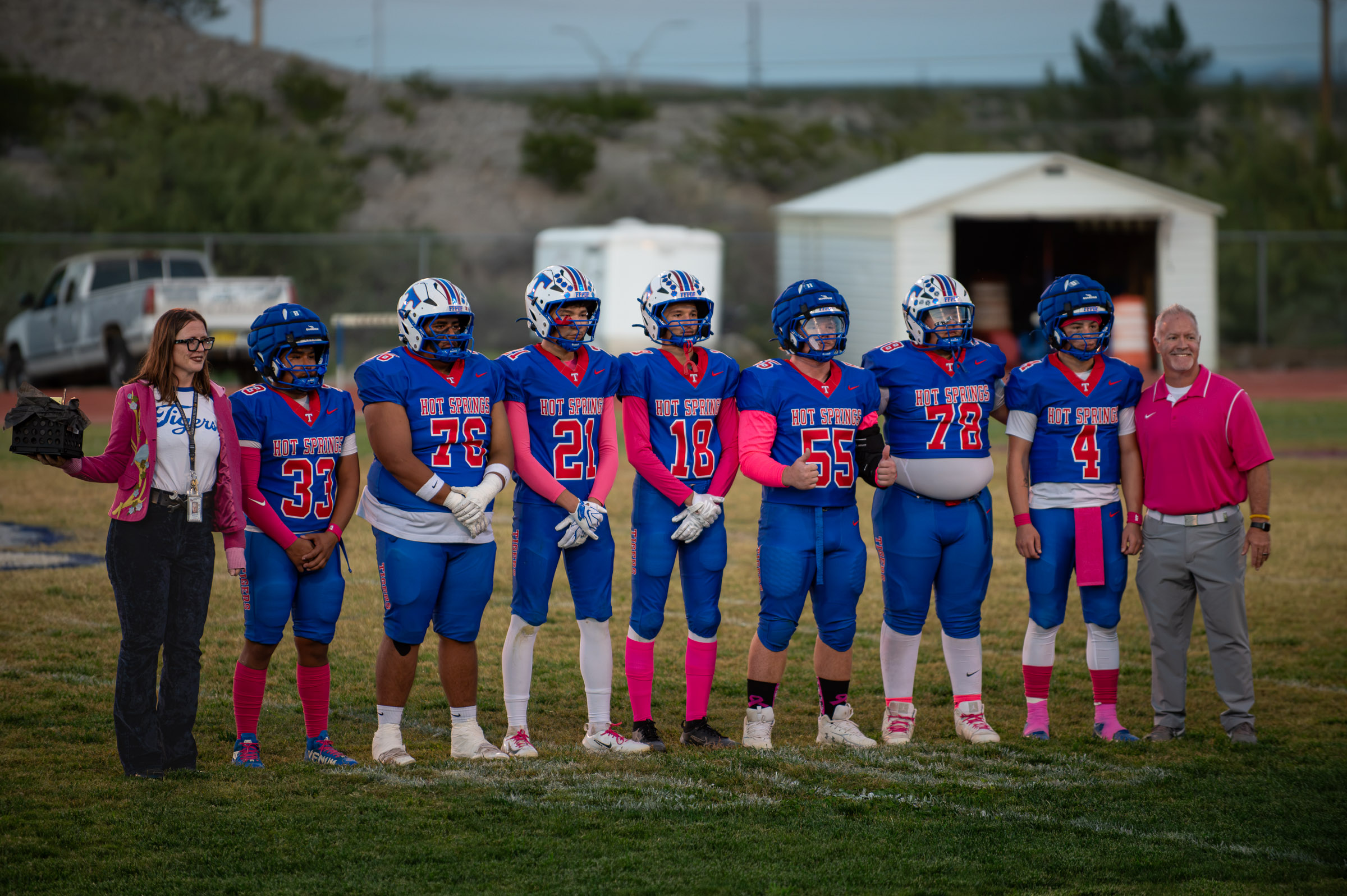 Hot Springs football players stand alongside school staff during a pregame recognition ceremony at Tiger Stadium.