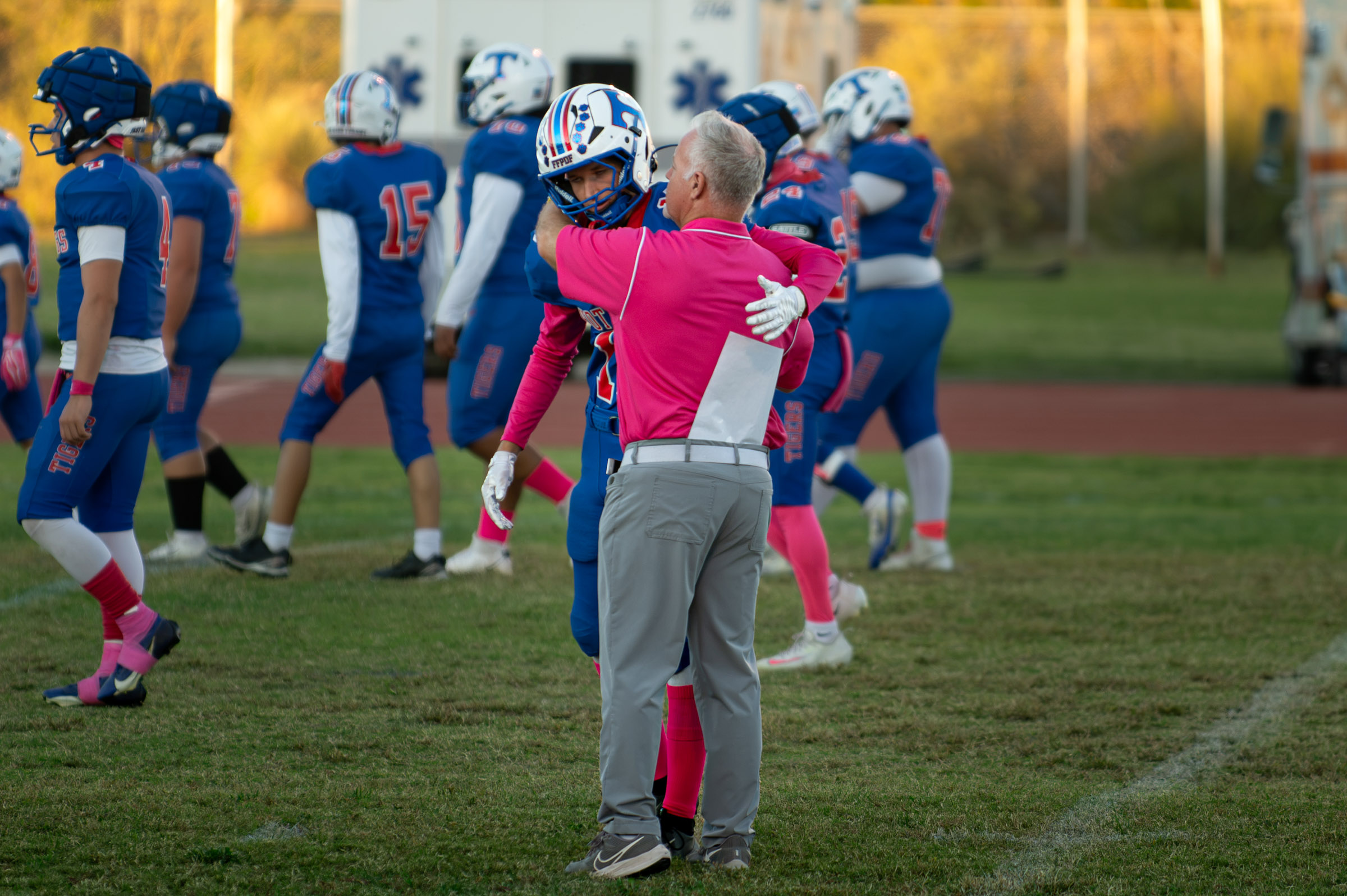 Hot Springs head coach Louis Howell embraces senior Billy Baca on the field before the Tigers’ game against Hatch Valley.