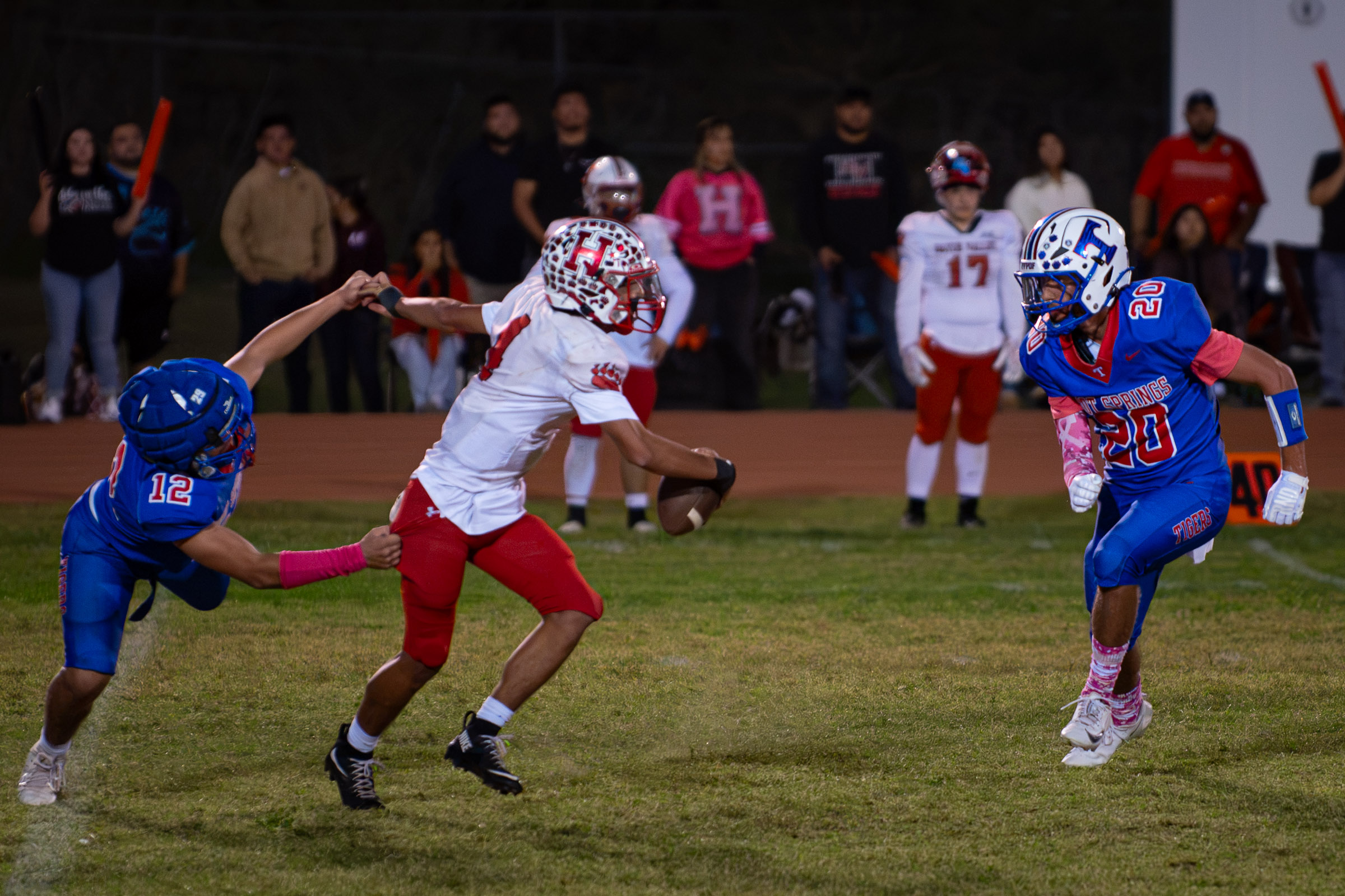 Hot Springs defenders Aaron Gill (#12) and Cole Montoya (#20) pursue Hatch Valley quarterback Nano Turner (#4) as he carries the ball.